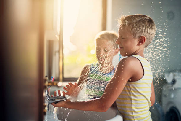 little boys washing hands and playing with water - family modern house window imagens e fotografias de stock