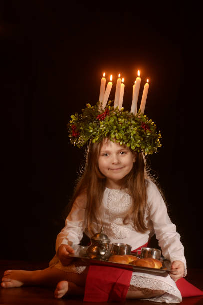 Little caucasian girl in Saint Lucia costume Little caucasian girl in Saint Lucia costume with crown of candles and traditional swedish sweet swedish girl stock pictures, royalty-free photos & images