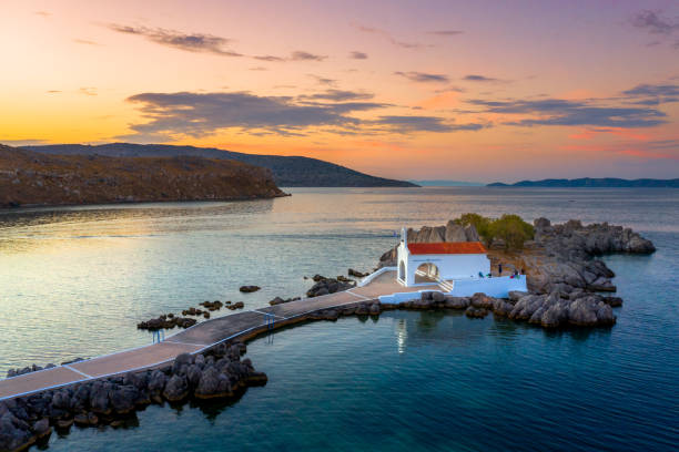Little church of Agios Isidoros in the sea over the rocks, Chios island, Greece. stock photo