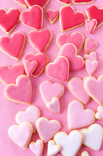 Little cookie hearts with pink icing on a pink background