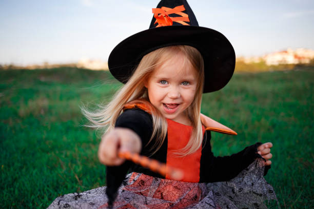 pequeña chica linda vestida como una bruja celebra halloween - halloween jack fotografías e imágenes de stock