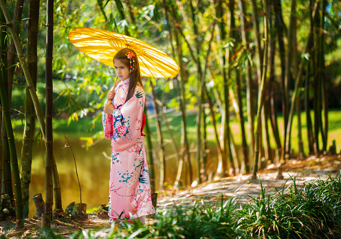 Little girl among bamboo garden