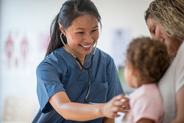 Little Girl at a Check Up with Her Mother A nurse is listening to a little girl's heartbeat at a doctors appointment. general practitioner stock pictures, royalty-free photos & images