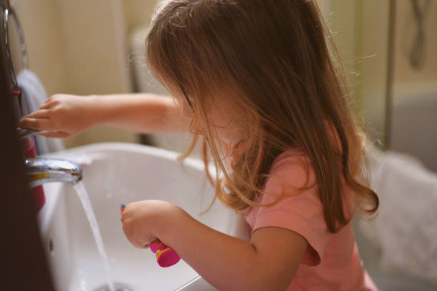 Little girl brushing her teeth stock photo