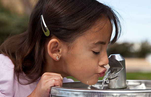 Little girl drinking from a water fountain Little girl drinking from a water fountain hot latino girl stock pictures, royalty-free photos & images