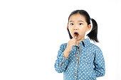 白い背景にロリポップを食べる小さな女の子