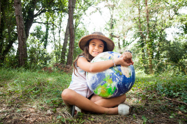 Little girl embracing world globe stock photo