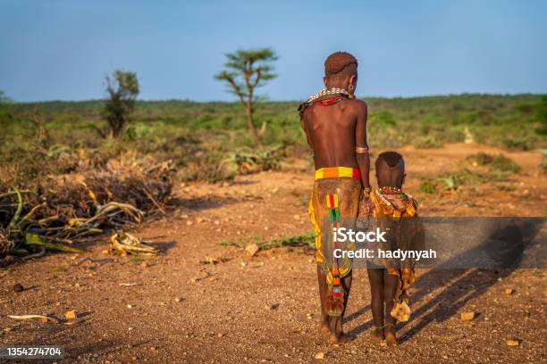 Little girl from Hamer tribe holding her little sister, Ethiopia, Africa