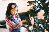 クリスマスツリーボーブルを持つ小さな女の子