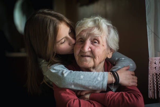 A little girl hugs her grandmother. stock photo