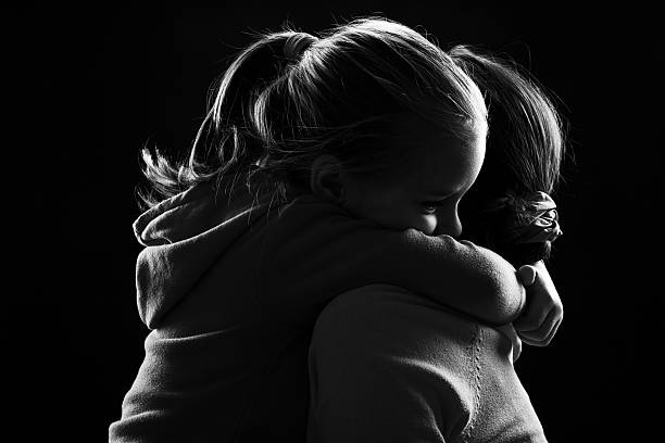 Little girl hugs her mother stock photo