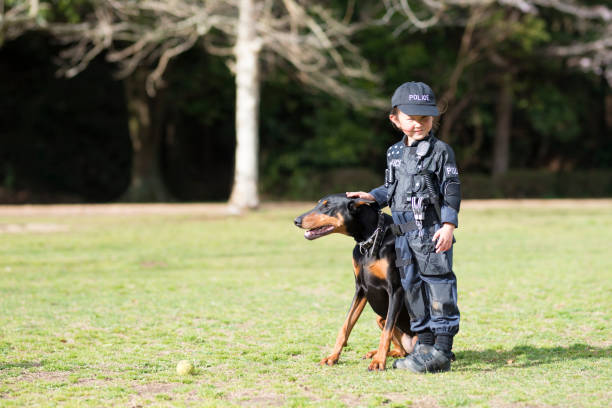 警察衣装とドーベルマンの相棒の少女 - 動物飼育管理　日本 ストックフォトと画像