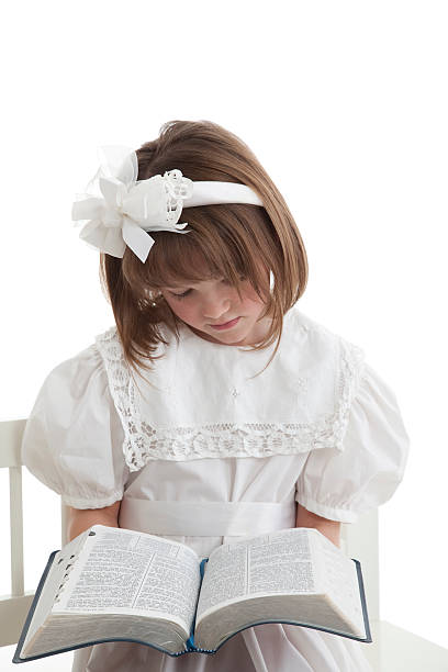 Little Girl In White Reading Her Scriptures stock photo