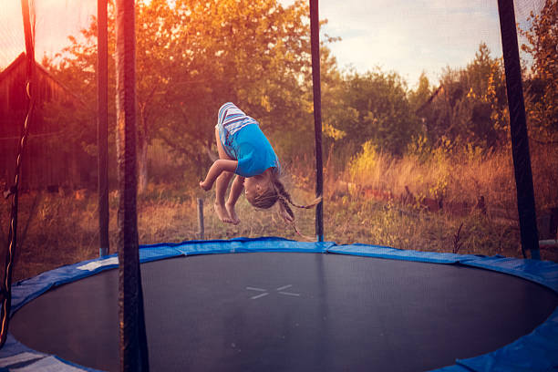 little girl jumping on the trampoline - trampoline girl stock photos and pi...