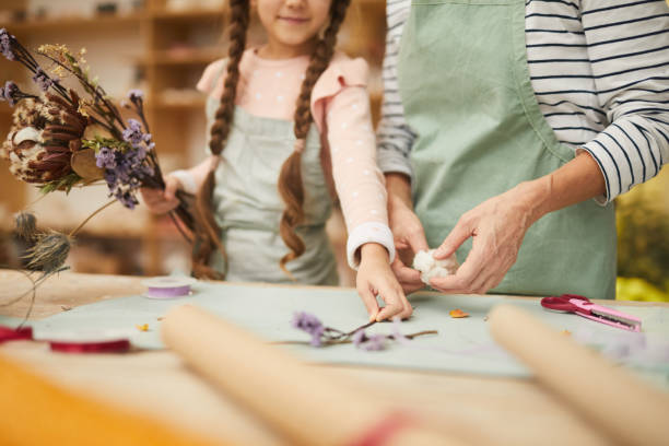 Little Girl Making Herbarium Mid section portrait of mother and daughter creating flower compositions in art studio, copy space dried plant photos stock pictures, royalty-free photos & images