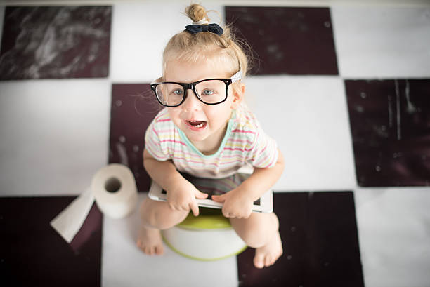 Little girl on a potty with digital tablet stock photo