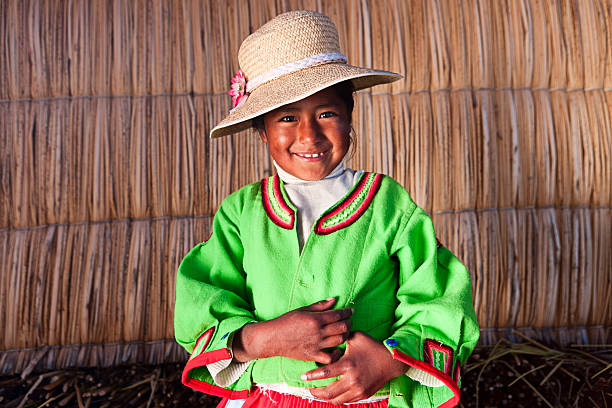 Little girl on Uros floating island Uros are a pre-Incan people that live on forty-two self-fashioned floating island in Lake Titicaca Puno, Peru and Bolivia. They form three main groups: Uru-Chipayas, Uru-Muratos  and the Uru-Iruitos. The latter are still located on the Bolivian side of Lake Titicaca and Desaguadero River. The Uros use bundles of dried totora reeds to make reed boats (balsas mats), and to make the islands themselves. The Uros islands at 3810 meters above sea level are just five kilometers west from Puno port.http://bem.2be.pl/IS/peru_380.jpg peru girl stock pictures, royalty-free photos & images
