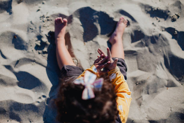 Little Girl Playing in Sand on the Beach stock photo