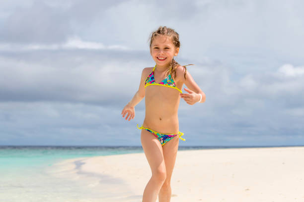 Little Girl Playing On Sandy Beach  little girls in bathing suits stock pictures, royalty-free photos & images