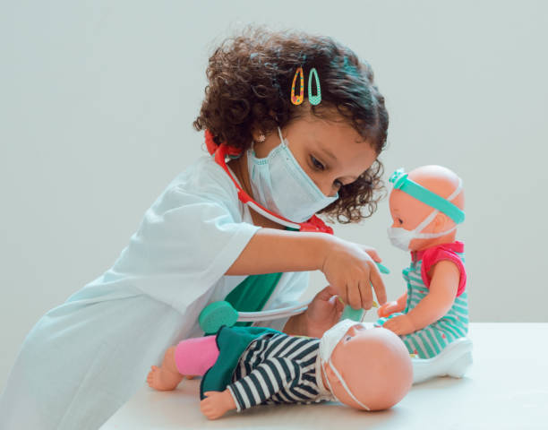 A little girl playing the doctor A little girl playing the doctor gives her patient an injection, they all wear protective masks dressing up stock pictures, royalty-free photos & images