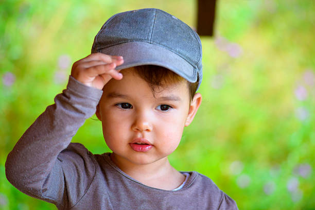 Little girl putting on her hat in summer time  hats off to you stock pictures, royalty-free photos & images