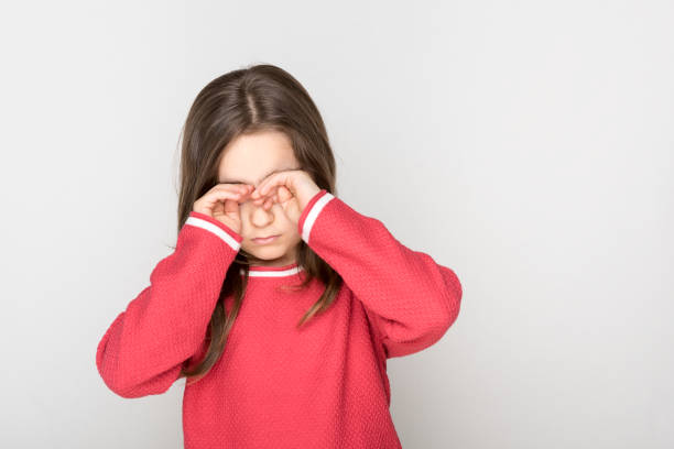 Little girl rubbed her eyes stock photo