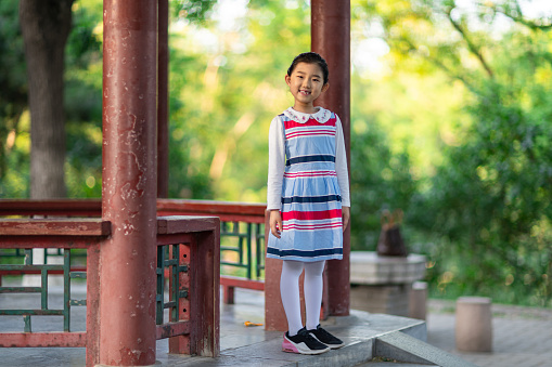 Little girl standing in a Chinese classical style pavilion
