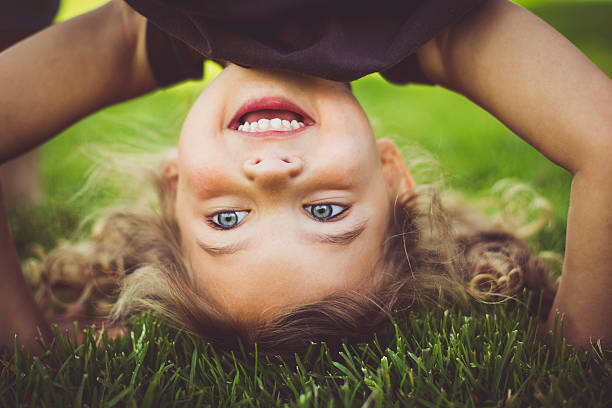 Little girl standing upside down. stock photo
