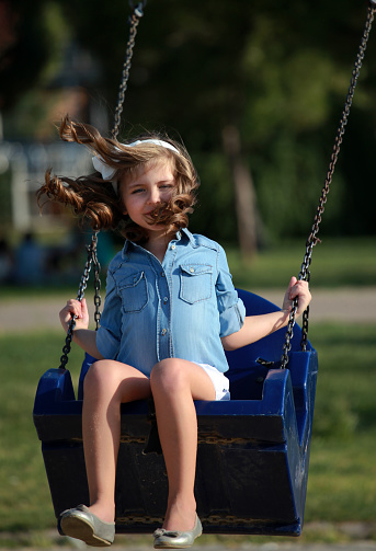 Cute Girl Swinging In Park Stock Photo - Download Image 