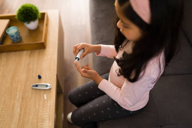 Little girl testing her glucose levels stock photo