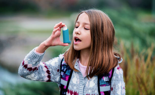 Little girl using asthma inhaler. Health care concept stock photo
