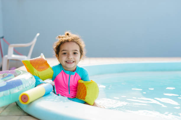 Little girl using float in the pool Summer hot latino girl stock pictures, royalty-free photos & images