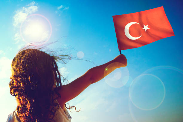 晴れた美しい日にトルコ国旗を振る小さな女の子