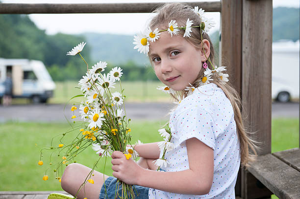 little girl with daisies in her hair stock photo