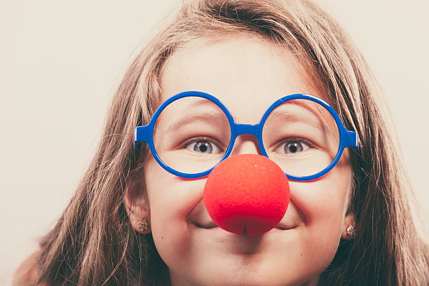 Little girl with red nose Little girl with red nose. Prepare to have fun, carnival time clown's nose stock pictures, royalty-free photos & images