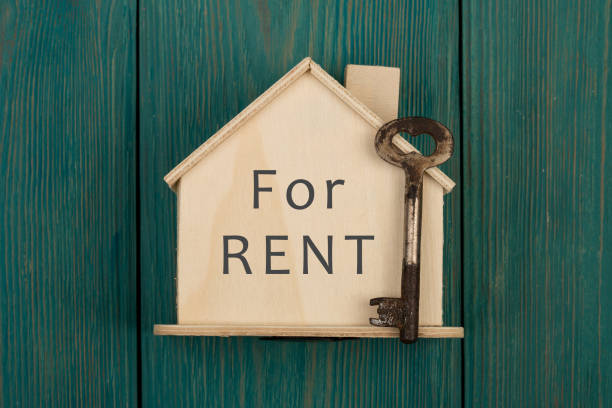 Little house with text "For rent" and key stock photo