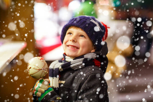 little kid boy eating sugar apple sweets stand on christmas mark - christmas magic imagens e fotografias de stock