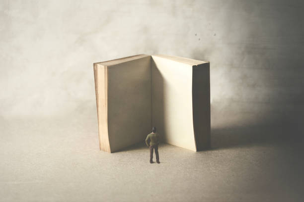 little man reading a big empty book, surreal concept stock photo