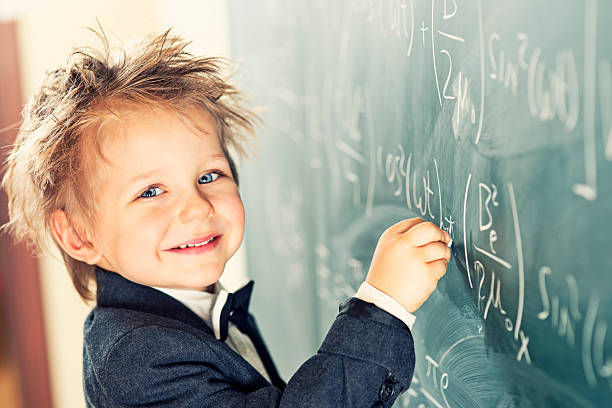 Little Scientist Cute little boy with messy hair solving difficult equations. e=mc2 stock pictures, royalty-free photos & images