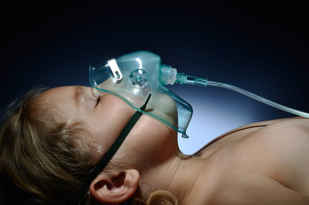 Little, sick girl in mask oxygen. stock photo