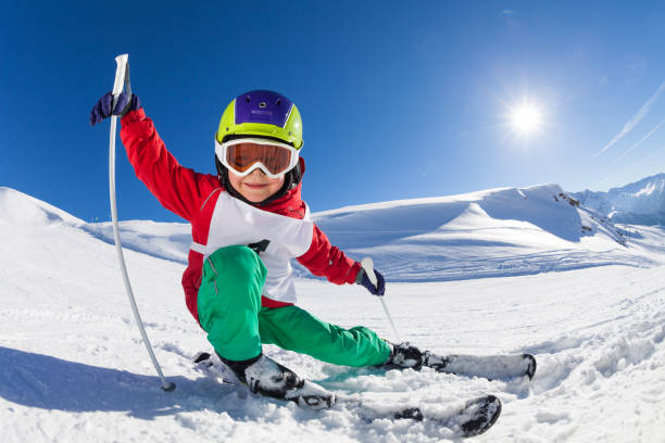 Little skier having fun at sunny snowy day stock photo