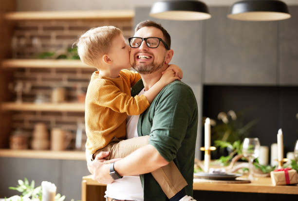 Little son kissing happy dad, congratulating him with Fathers da stock photo