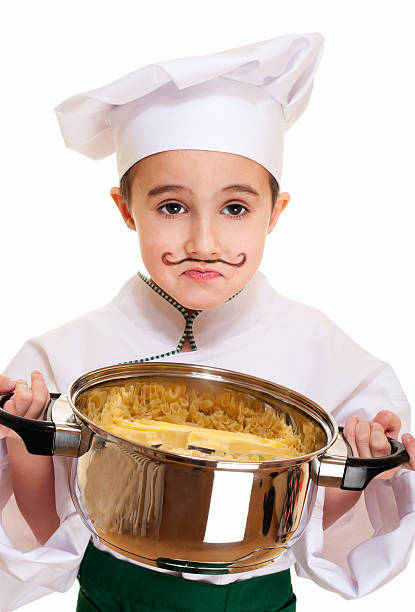 Little unhappy cook with pot of pasta stock photo