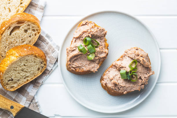 Liver pate on sliced baguette. Liver pate on sliced baguette on plate. Top view. pate stock pictures, royalty-free photos & images