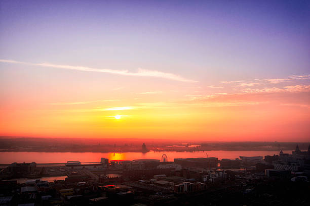 Liverpool city sunset High view of Liverpool City and the River Mersey leading onto the Wirral peninnsula as the sunsets on a spring evening river mersey liverpool stock pictures, royalty-free photos & images