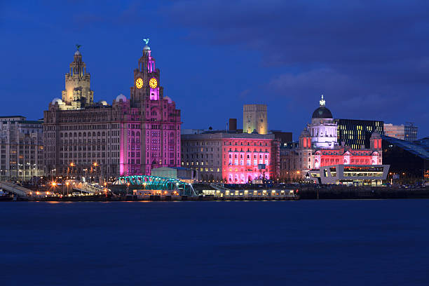 Liverpool Waterfront at Night Night view of  Liverpool Pier head showing the Three Graces. river mersey liverpool stock pictures, royalty-free photos & images
