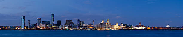 Liverpool waterfront night panorama "Panoramic view across the Mersey at the Liverpool waterfront at night. On the left are a cluster of new offices and flats that form the financial district. In the centre is Pier Head part of a UNESCO World Heritage Site which includes the Three Graces, the Royal Liver Building, the Cunard Building and the Port of Liverpool Building. On the right is the Mann Island Buildings a new development which includes The Museum of Liverpool and Albert Dock which houses the Tate Liverpool a modern art gallery." cunard building liverpool stock pictures, royalty-free photos & images