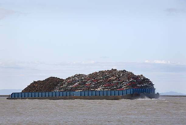 Loaded Scrap Metal Recycling Barge Scrap metal barge loaded with crushed cars for recycling. barge stock pictures, royalty-free photos & images