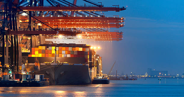 loading cargo container ship in commercial dock at night - rotterdam stockfoto's en -beelden