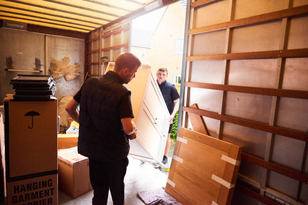 Loading furniture into removal truck Removal company helping a family move out of their old home relocation photos stock pictures, royalty-free photos & images